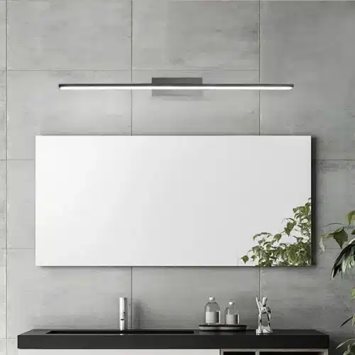 Lustre bar long LED mural fixé au mur gris au-dessus d’un comptoir noir; miroir blanc et plante à droite.