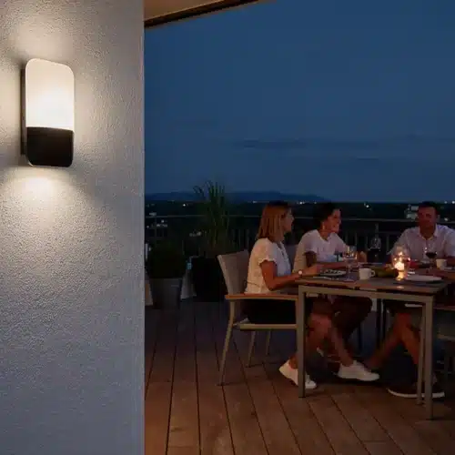 Applique murale extérieure moderne illuminant une terrasse en soirée sans éblouissement.