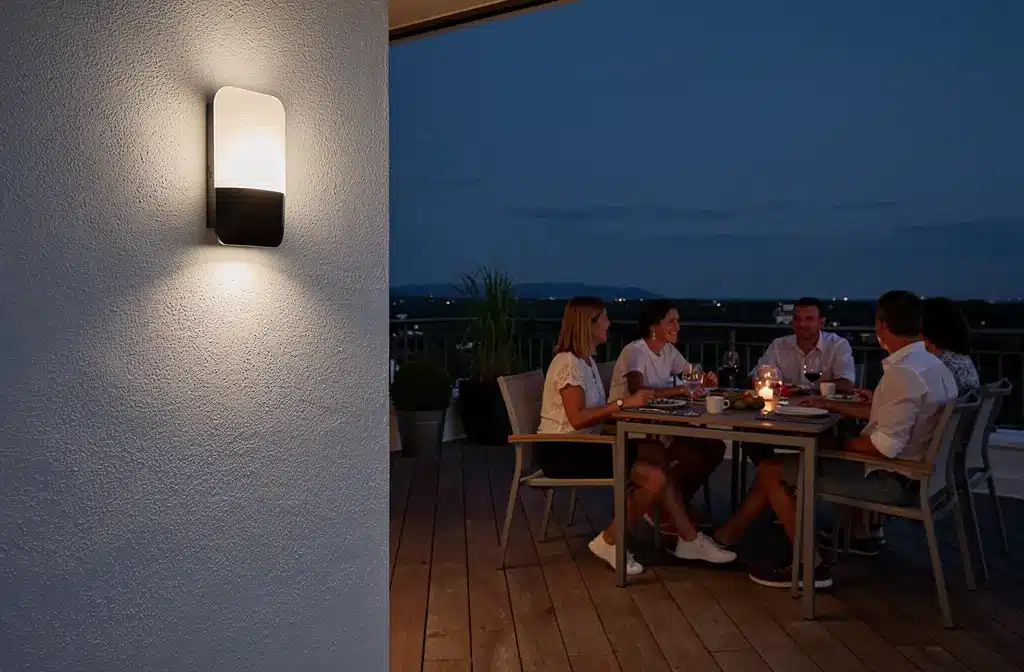 Applique murale extérieure moderne illuminant une terrasse en soirée sans éblouissement.