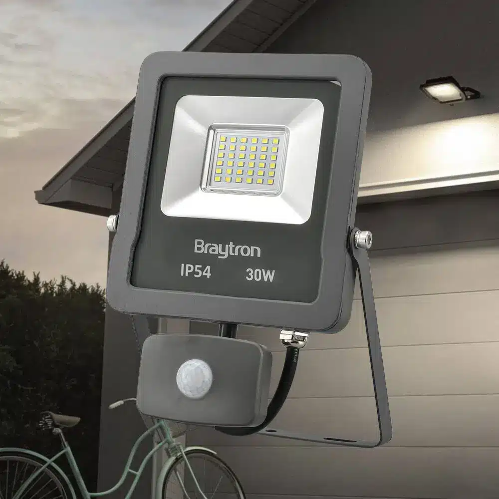 Projecteur LED Braytron 30W IP54 avec détecteur de mouvement et façade grise, extérieur, monté sur support, éclairage façade.