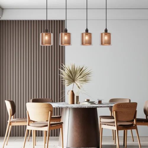 Suspension lumineuse à quatre rayons au-dessus d'une table en bois, ambiance chaleureuse et décor moderne avec plantes et chaises en bois.