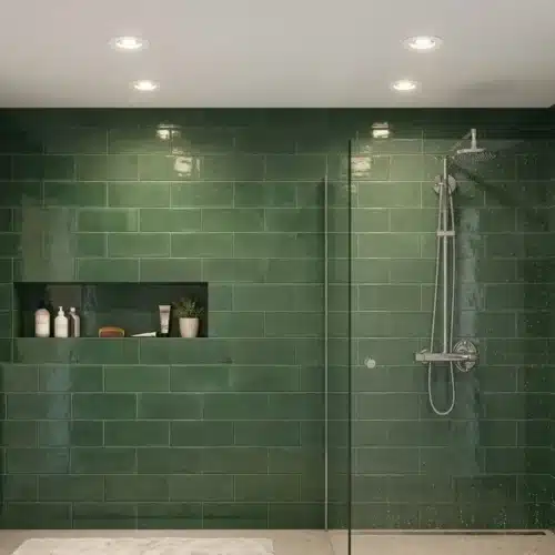 Spots LED encastrés au plafond d'une salle de bain moderne avec douche et carrelage vert.